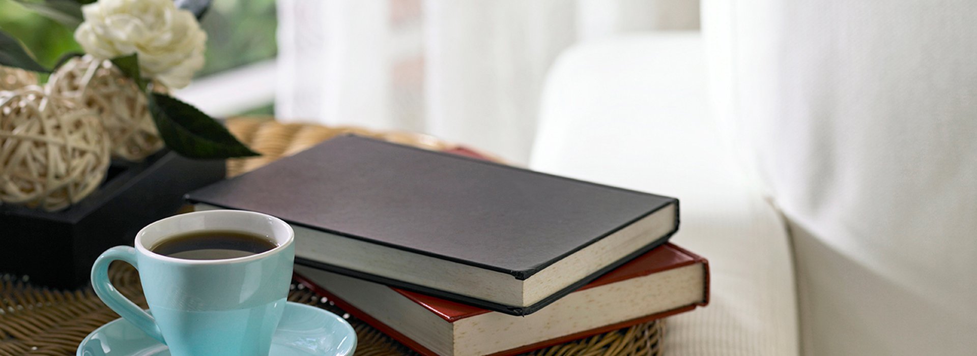 tea cup and books on a side table in a livingroom